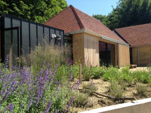 View of a museum building with pitched roofs covered in red tiles and vertical zinc cladding to walls completed by Kingsley Roofing