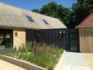 Black Zinc cladding, pitched, tiled roofs and sweet chestnut shake roof at the open air museum in Chichester.