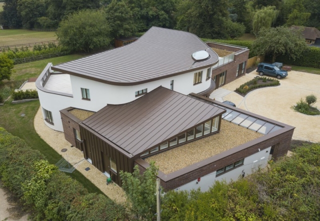 Flat roof and detail in zinc creating an aeroplane wing design.